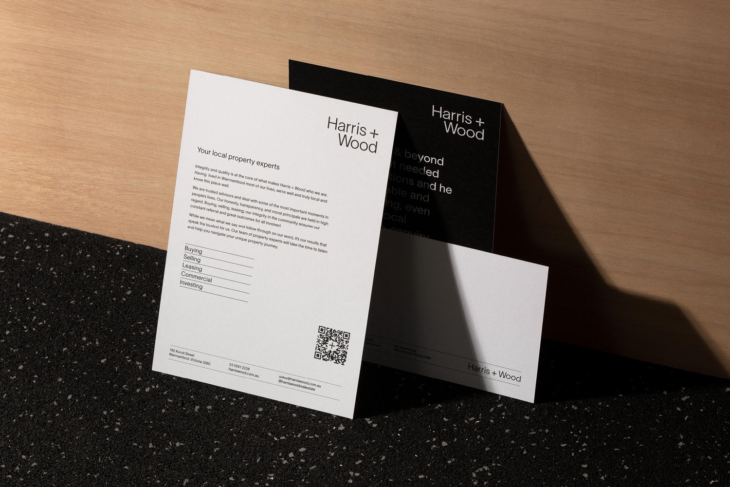 A cluster of printed Harris + Wood brand and property flyer designs