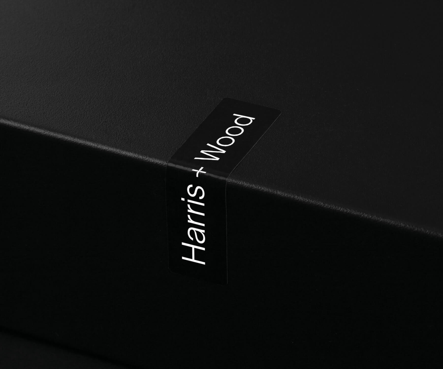 Black Harris + Wood branded sticker wrapped around a presentation box